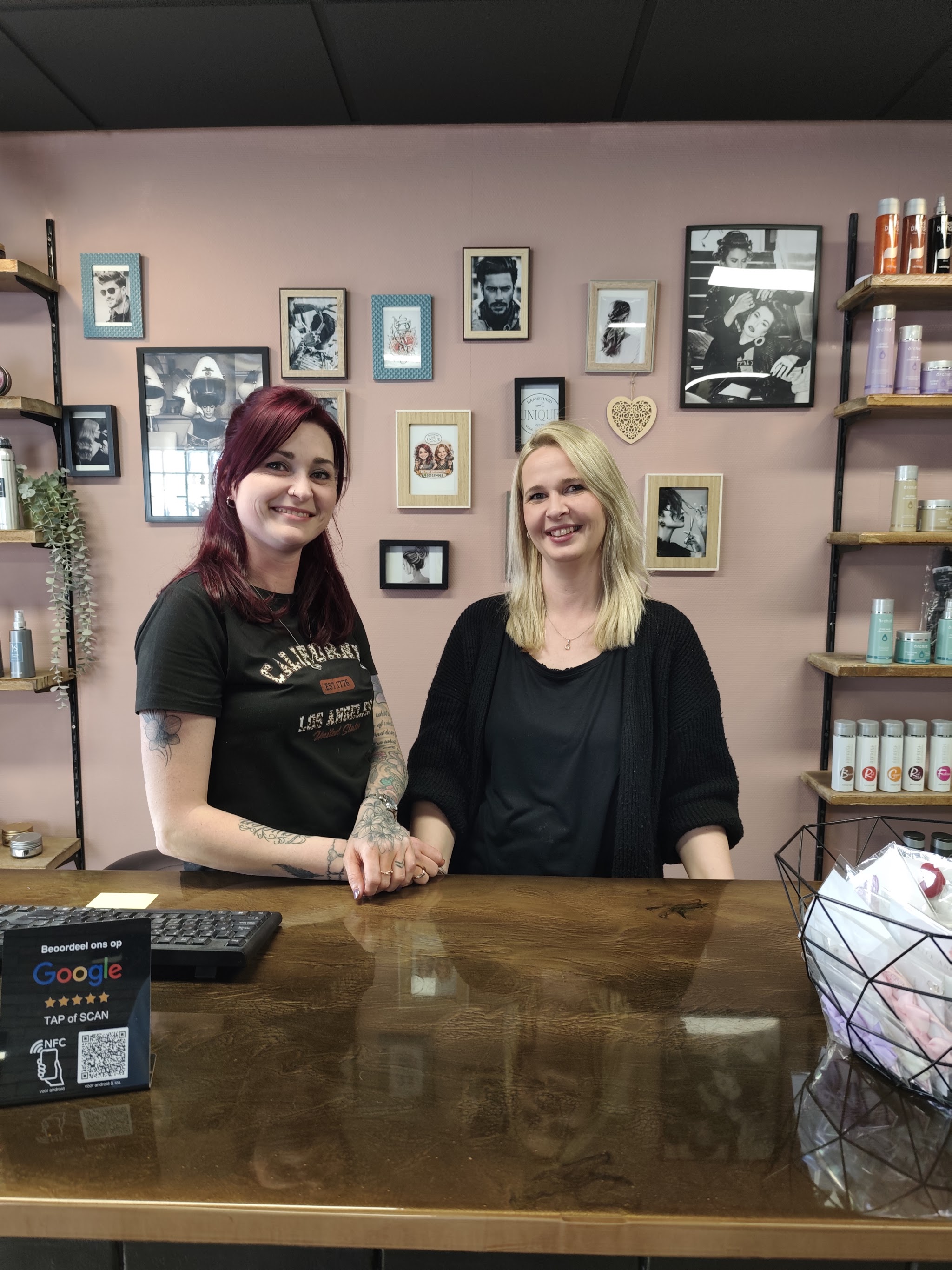 Twee medewerkers achter de receptie van de salon